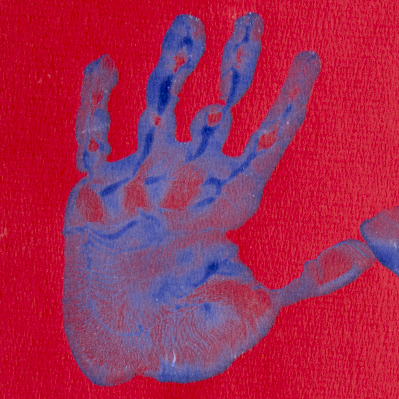 A blue handprint on red paper