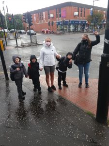 Five children in a line outside in the rain