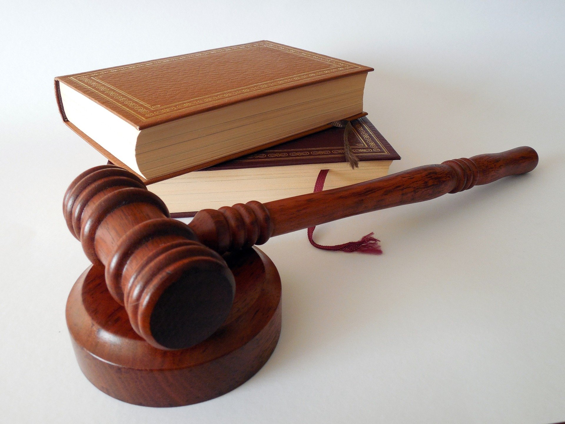 A wooden gavel and block with two hardback books behind it