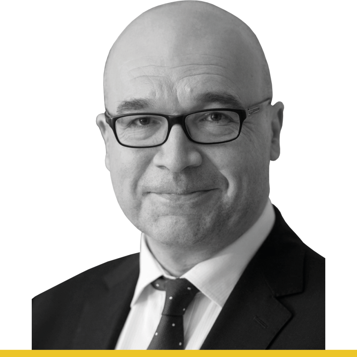 A black and white headshot of a man wearing a suit jacket, shirt, tie and glasses