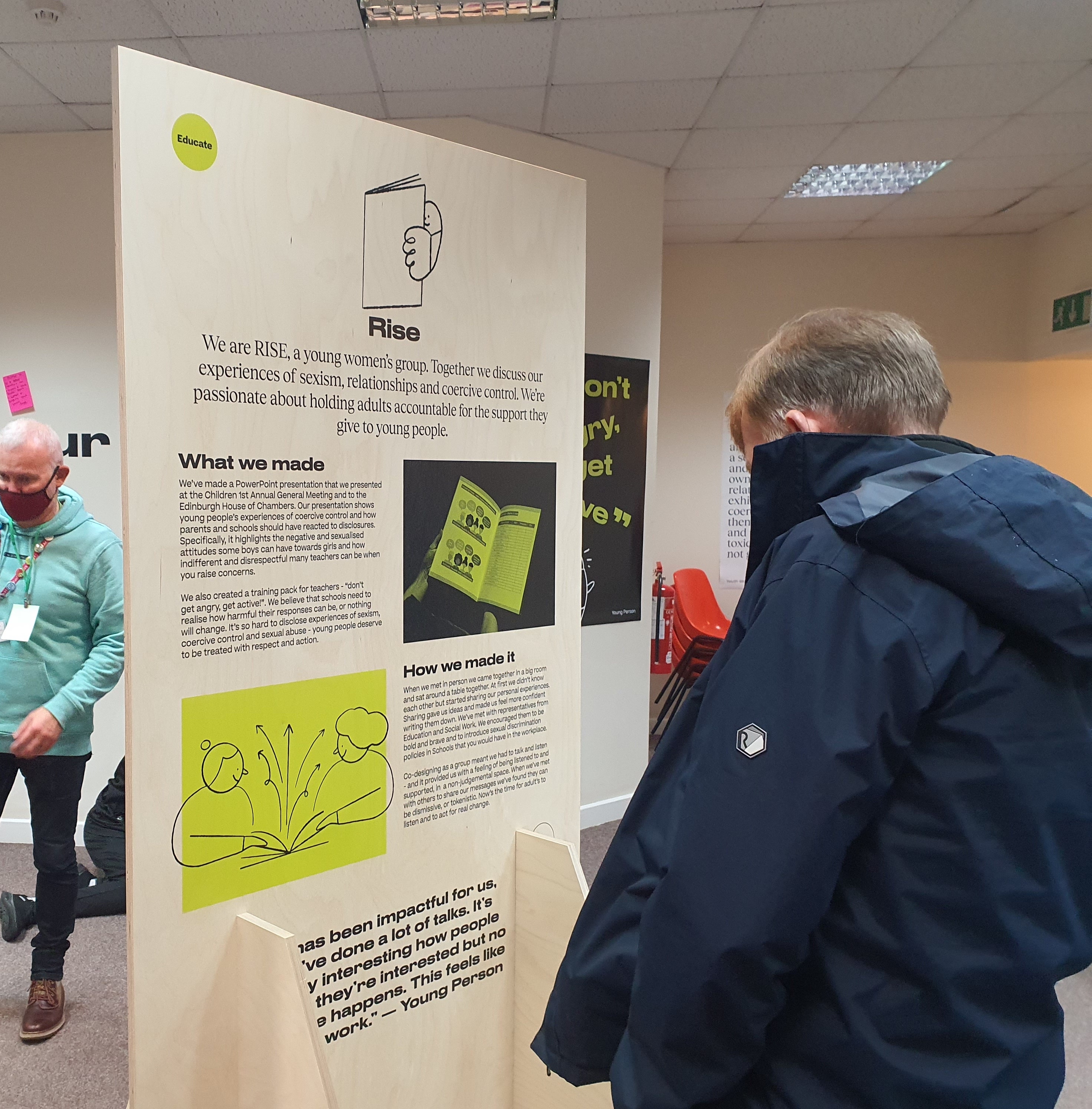 Man reading a large exhibition board