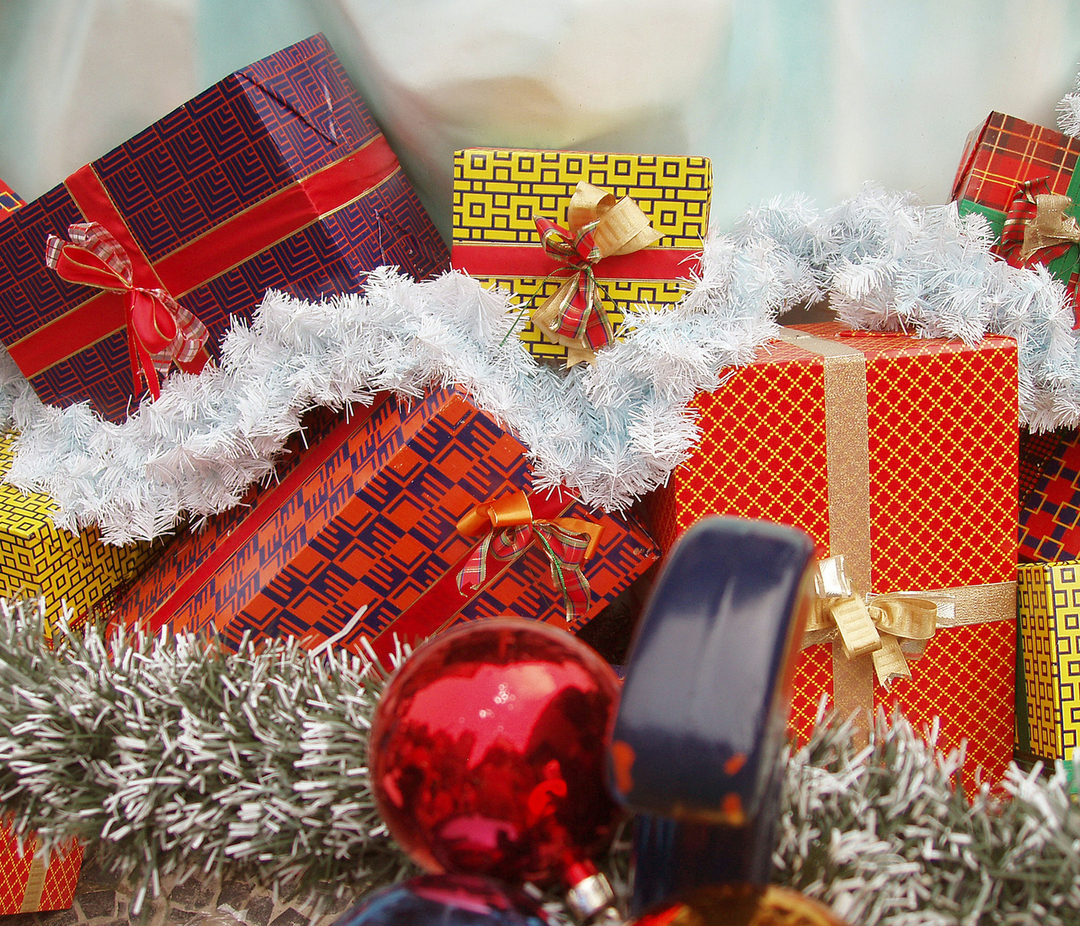 A photo of Christmas gifts wrapped up and surrounded by tinsel