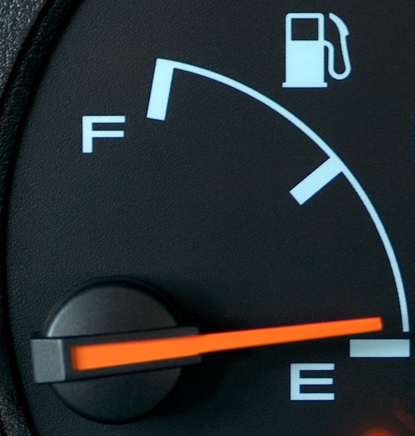 A photo of a car's fuel level, with the indicator pointing towards the 'empty' symbol.