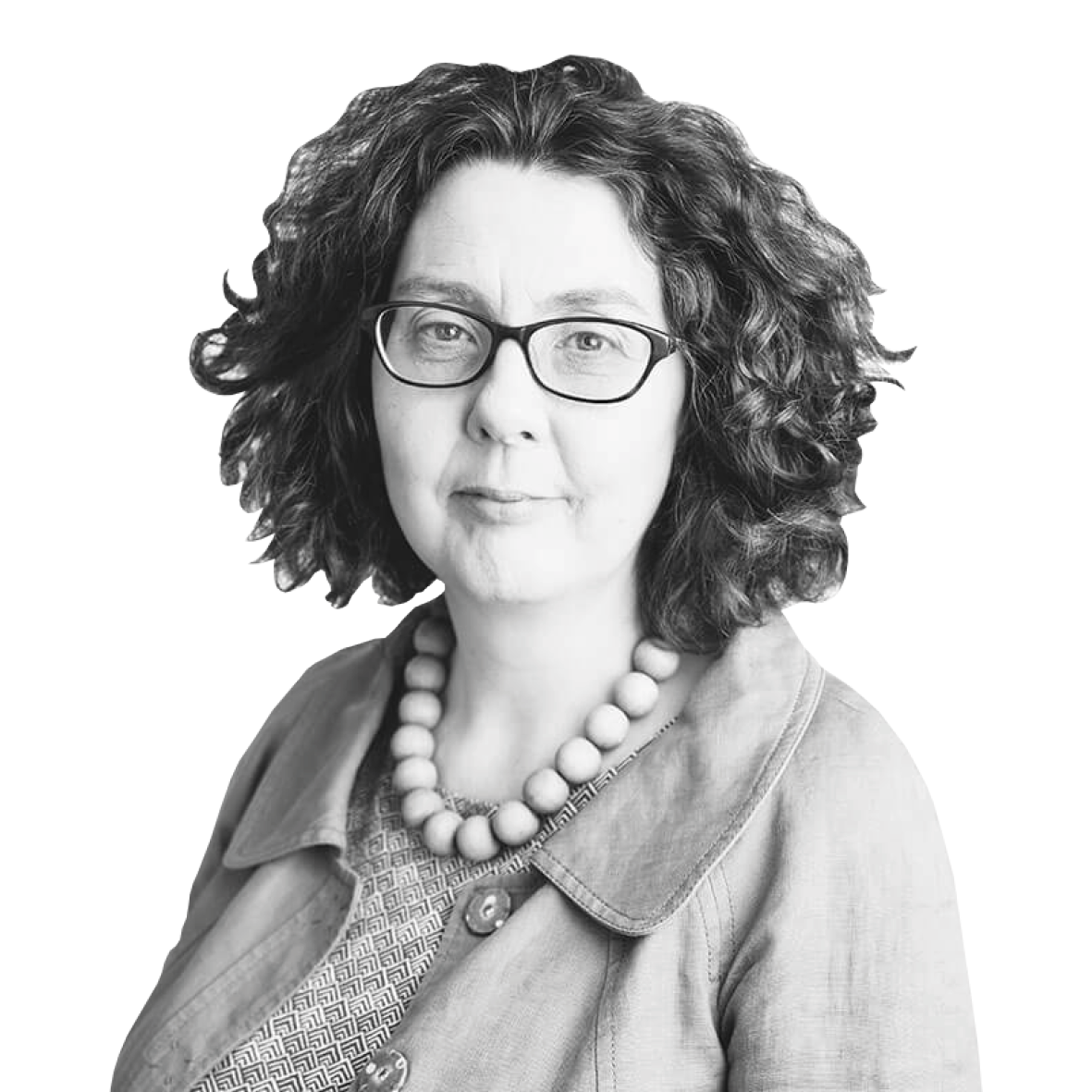 A black and white image of a person wearing glasses and a jacket with a string of large beads around their neck. They have dark curly hair to shoulder length