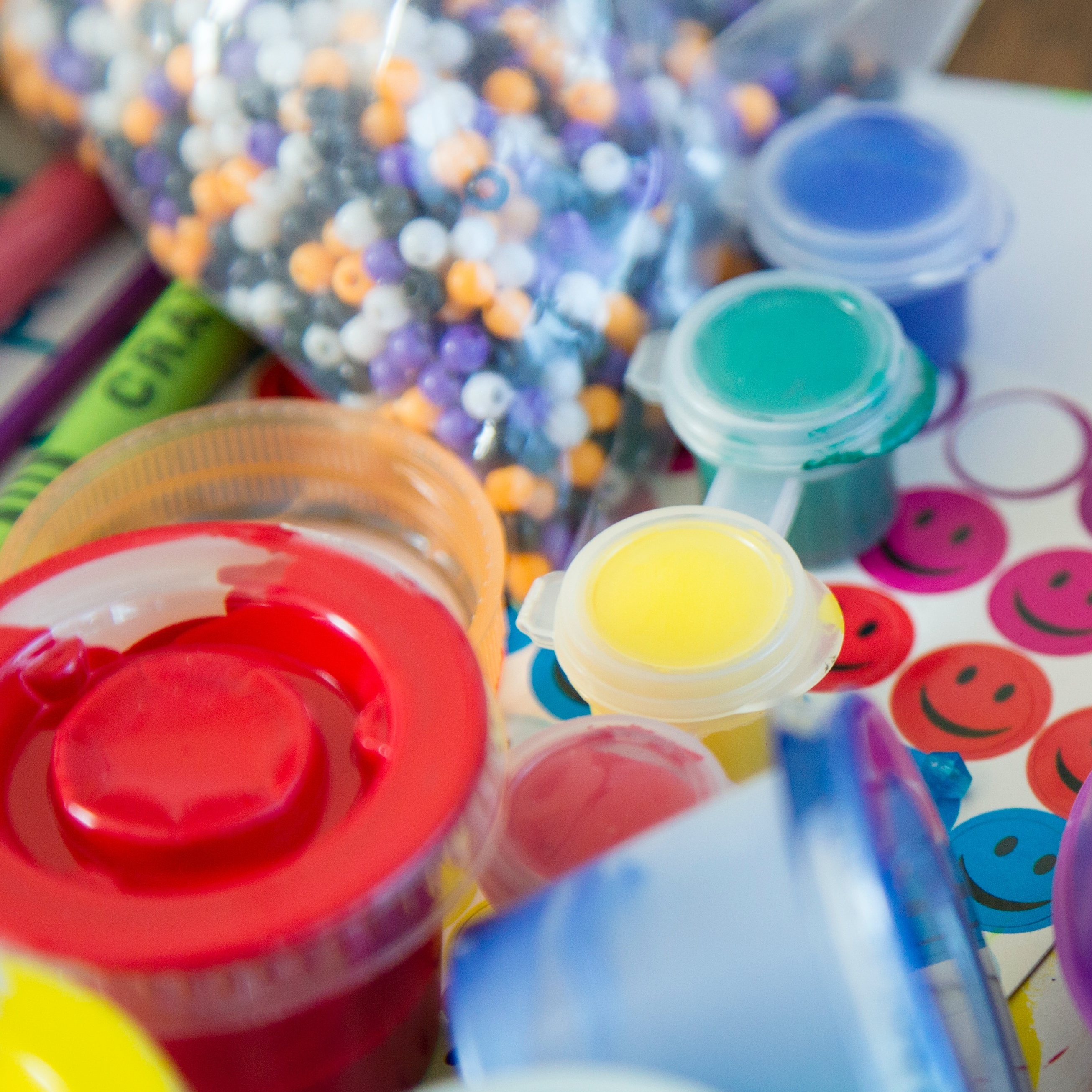 Pots of paint, smiley face stickers and other art supplies