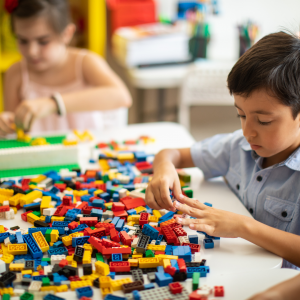 Young child playing with lego of various colours