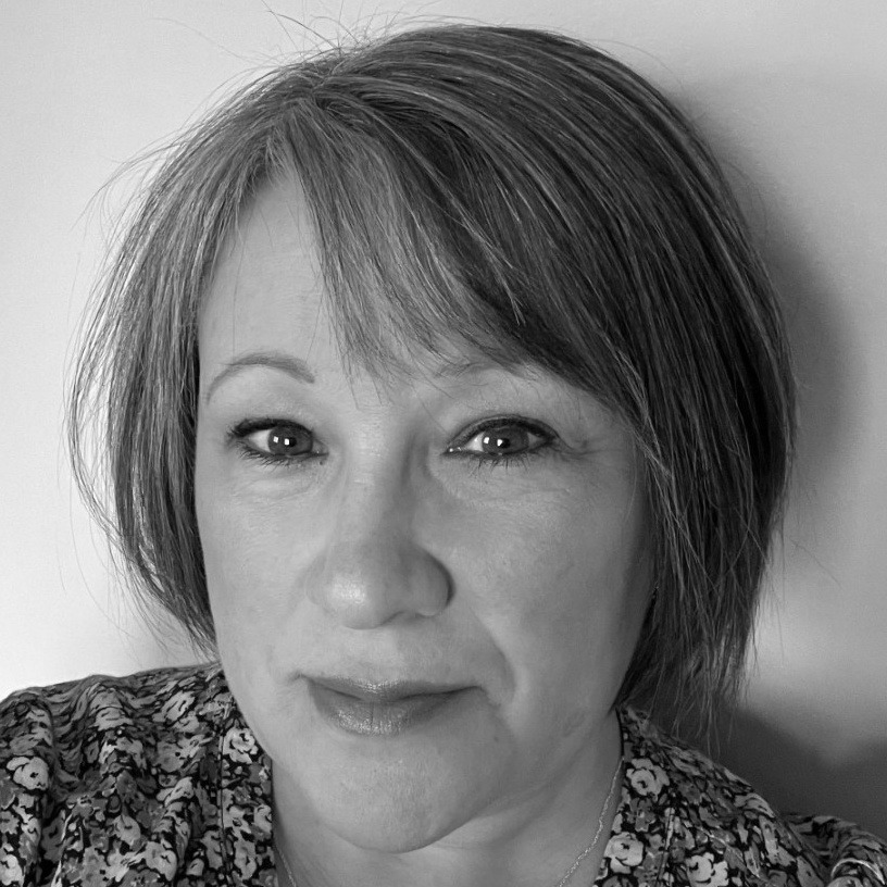 A greyscale inage of a person with short dark hair with a fringe.