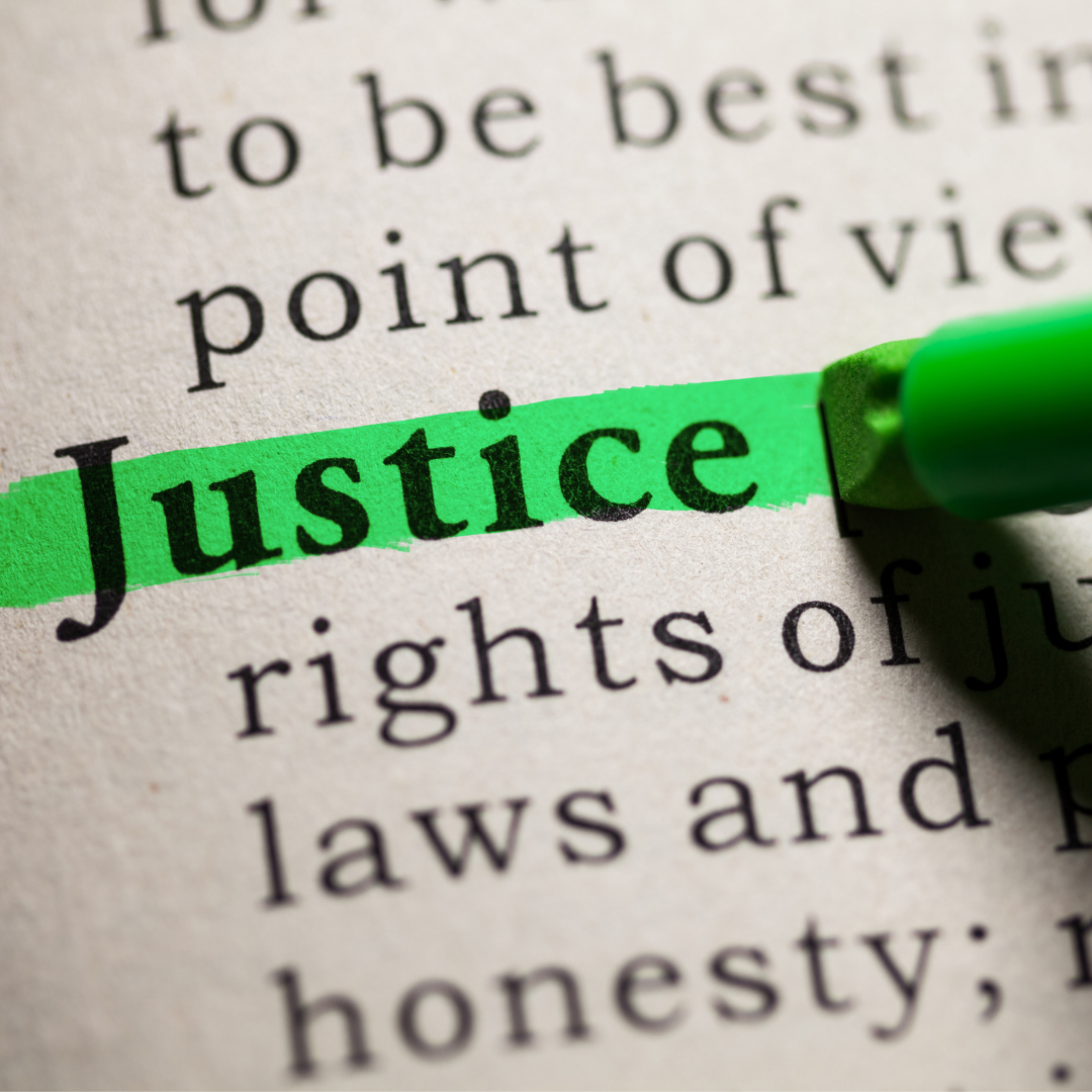 The word "justice" is highlighted in green marker on a page in a book