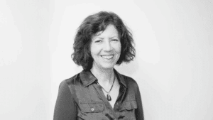 photo of person with medium length wavy hair, smiling wearing a shirt