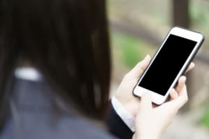 Secondary school pupil holding a smartphone with a blank screen