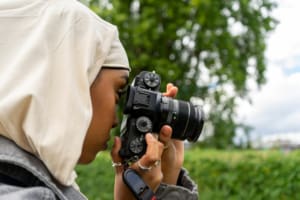 Close-up of young woman wearing hijab photographing with digital camera