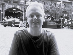 photo of person in t-shirt with building in background
