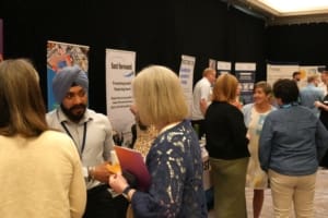 people talking & mingling at an event, with stands