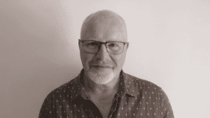 Image of a man with short hair, glasses and beard